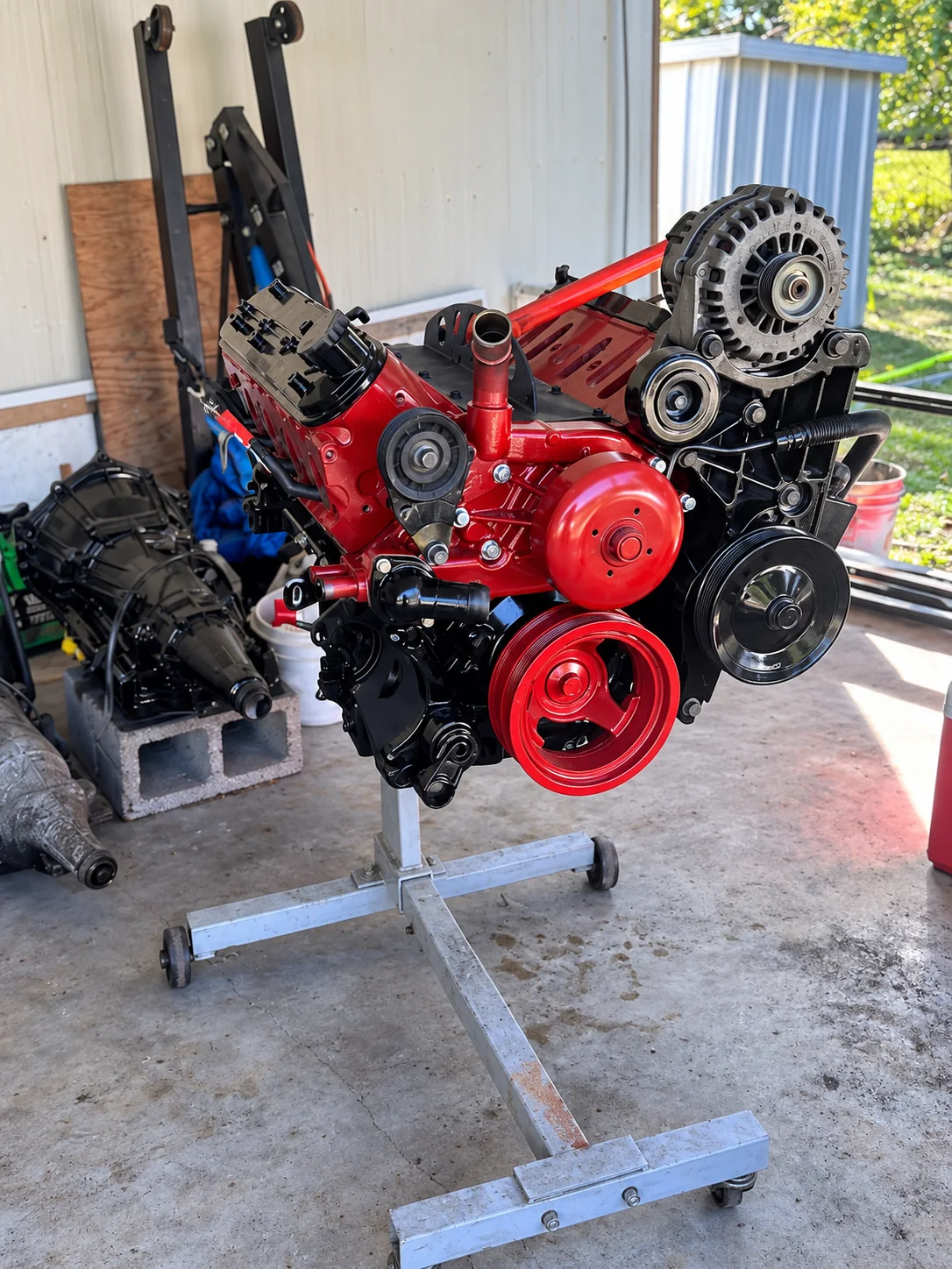 Red engine on a stand with front accessories and pulleys visible